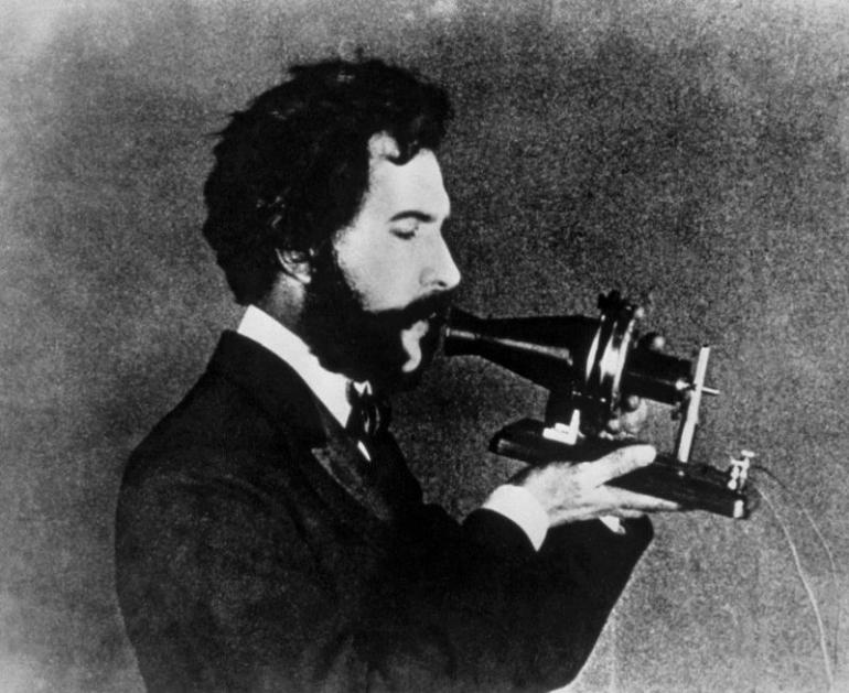 Alexander Graham Bell se svým modelem telefonu v roce 1876