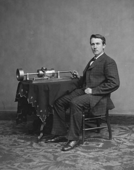 T. A. Edison na dobové fotografii s jedním ze svých plně mechanických modelů fonografu